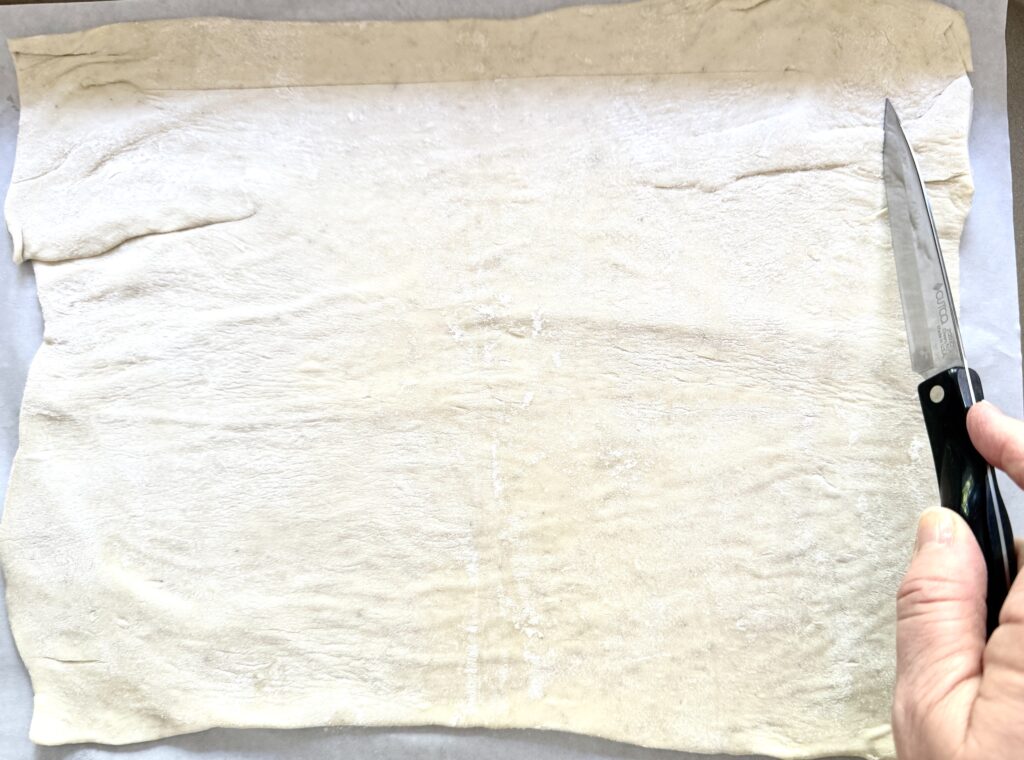 cutting puff pastry with knife