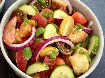 Bread and tomato salad in white bowl