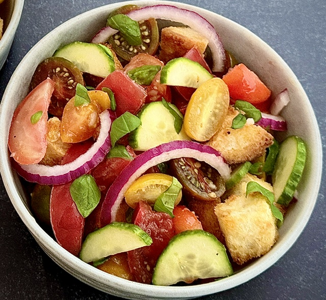 Bread and tomato salad in white bowl